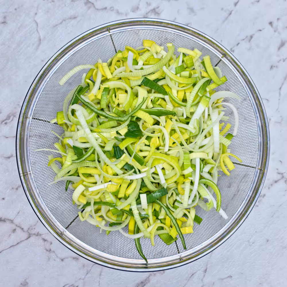  Leeks finely sliced and washed in a metal colander. 